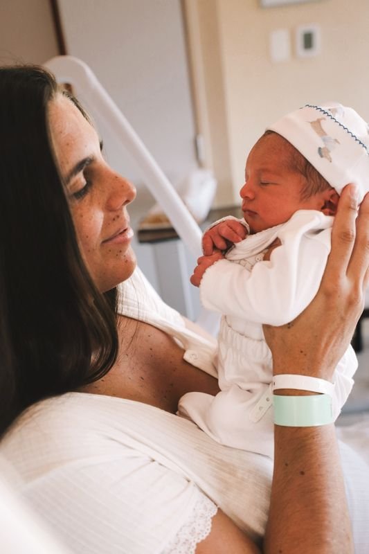 Mamá en el sanatorio alzando a su recién nacido